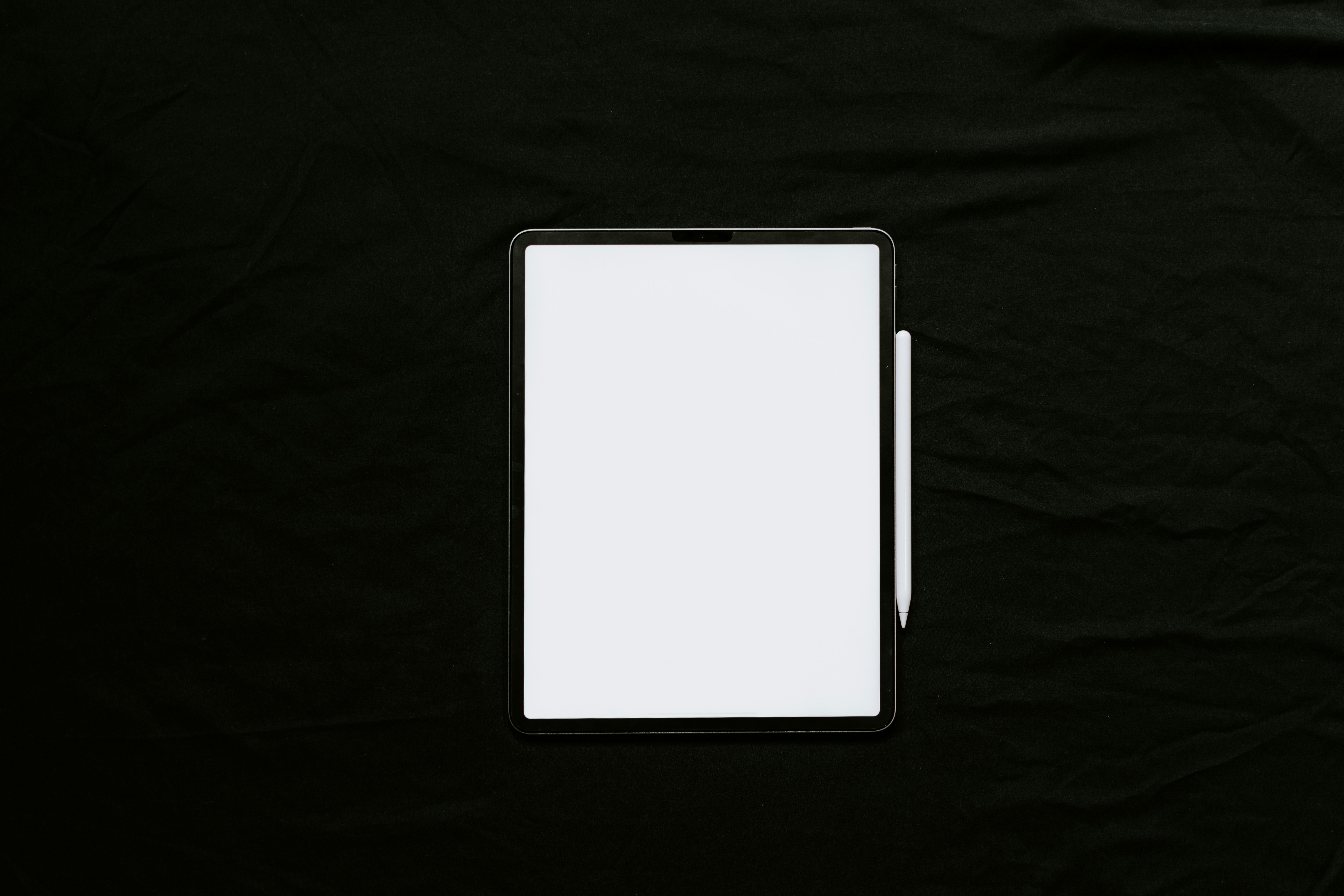 white tablet computer on black textile